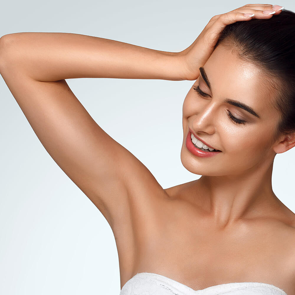 Young woman touching her head with her arm raised